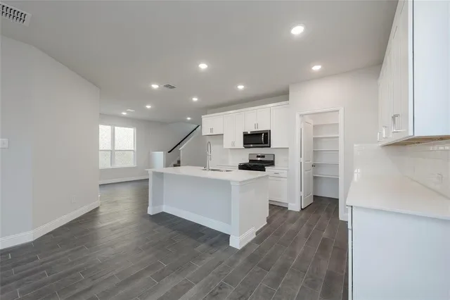a kitchen with white cabinets and stainless steel appliances