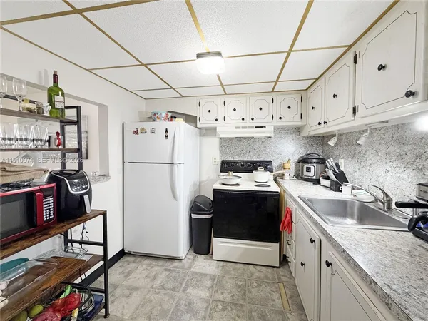 a kitchen with refrigerator and cabinets