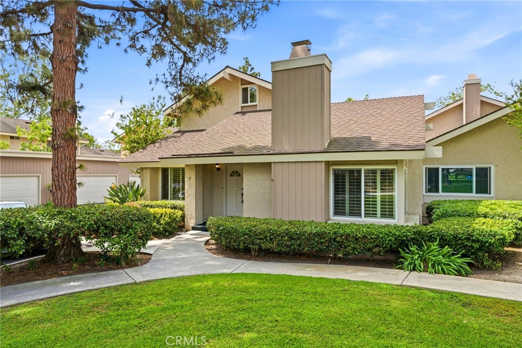 a front view of a house with a yard and potted plants