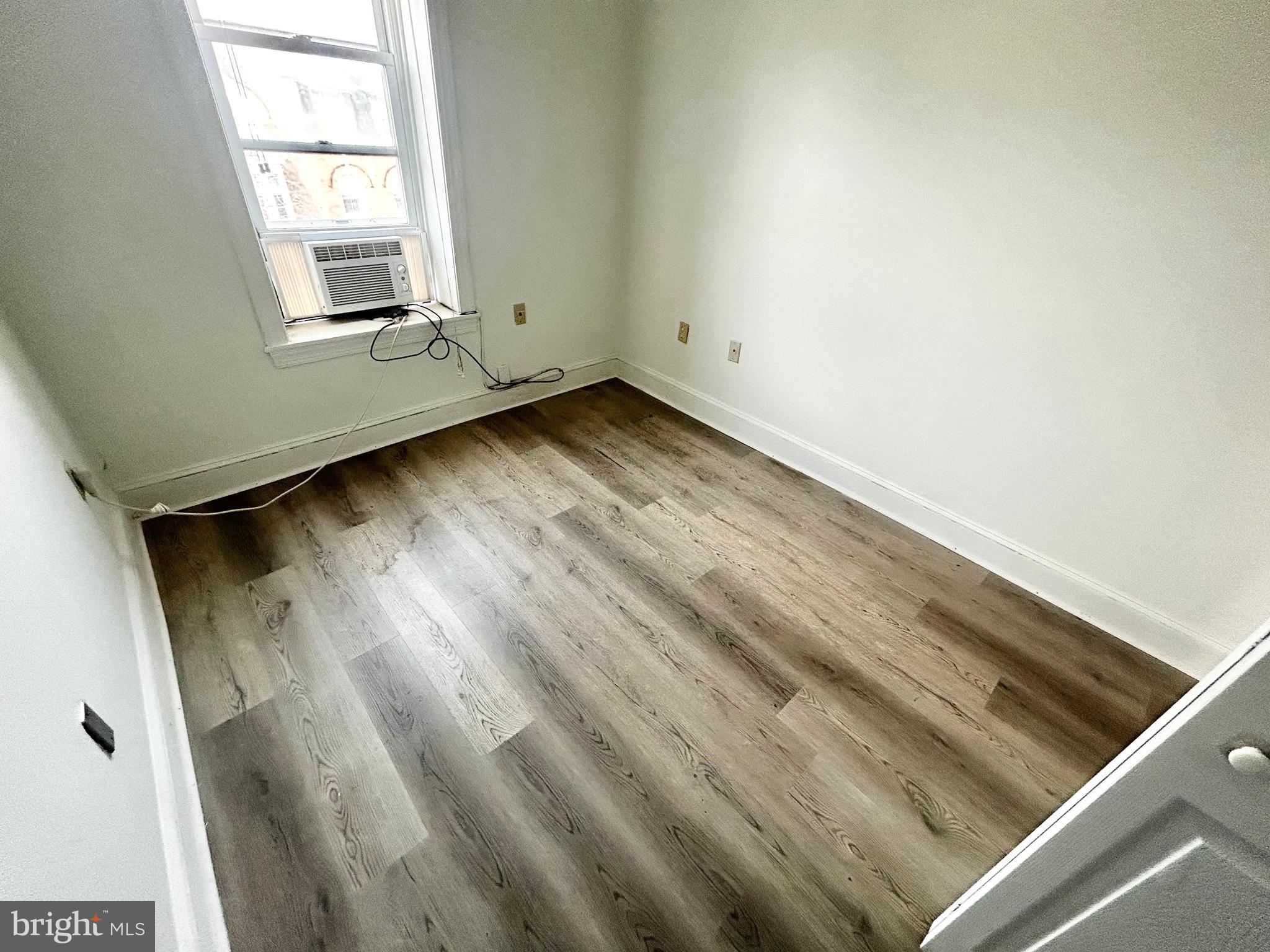 3618 Spring Garden Street, Unit 3 Philadelphia, PA 19104 - Photo 7 of 13 an empty room with wooden floor and windows