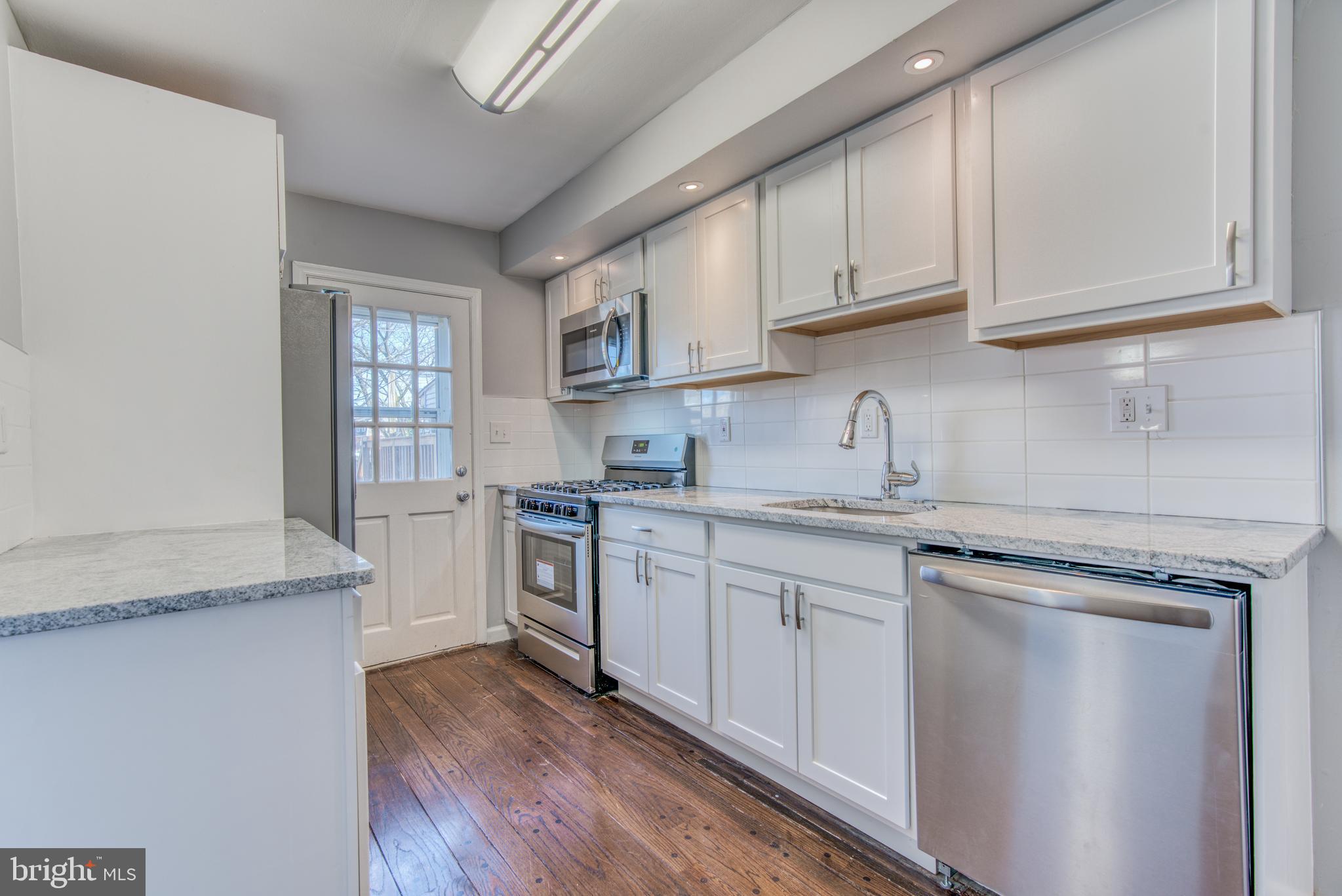 531 Grovethorn Road Baltimore, MD 21220 - Photo 12 of 56 a kitchen with granite countertop white cabinets and white appliances