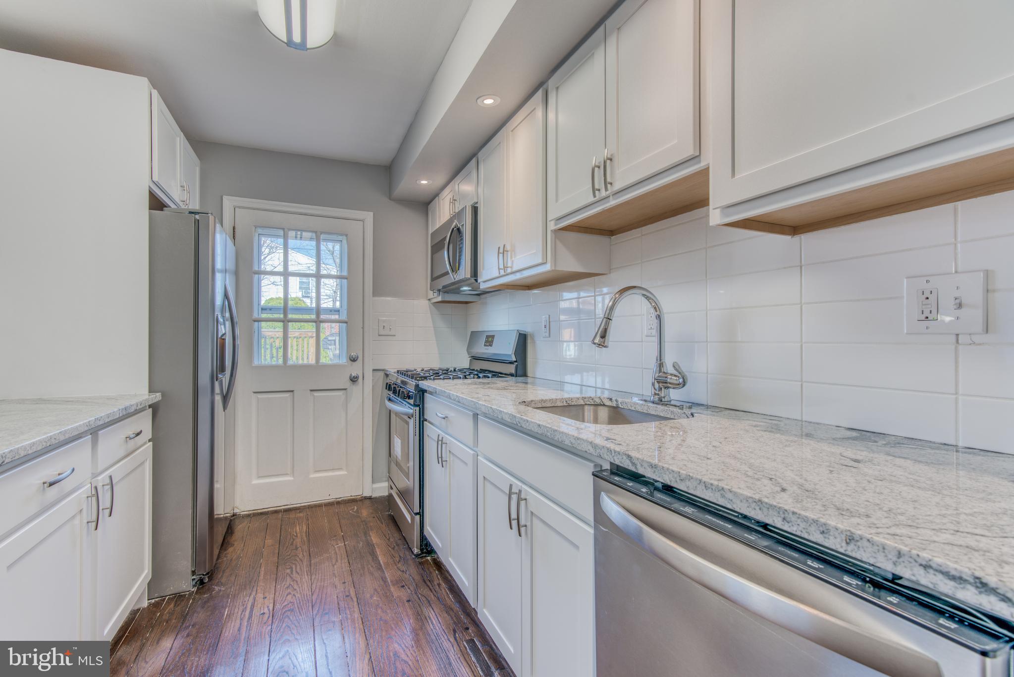 531 Grovethorn Road Baltimore, MD 21220 - Photo 13 of 56 a kitchen with a sink cabinets stainless steel appliances and a window