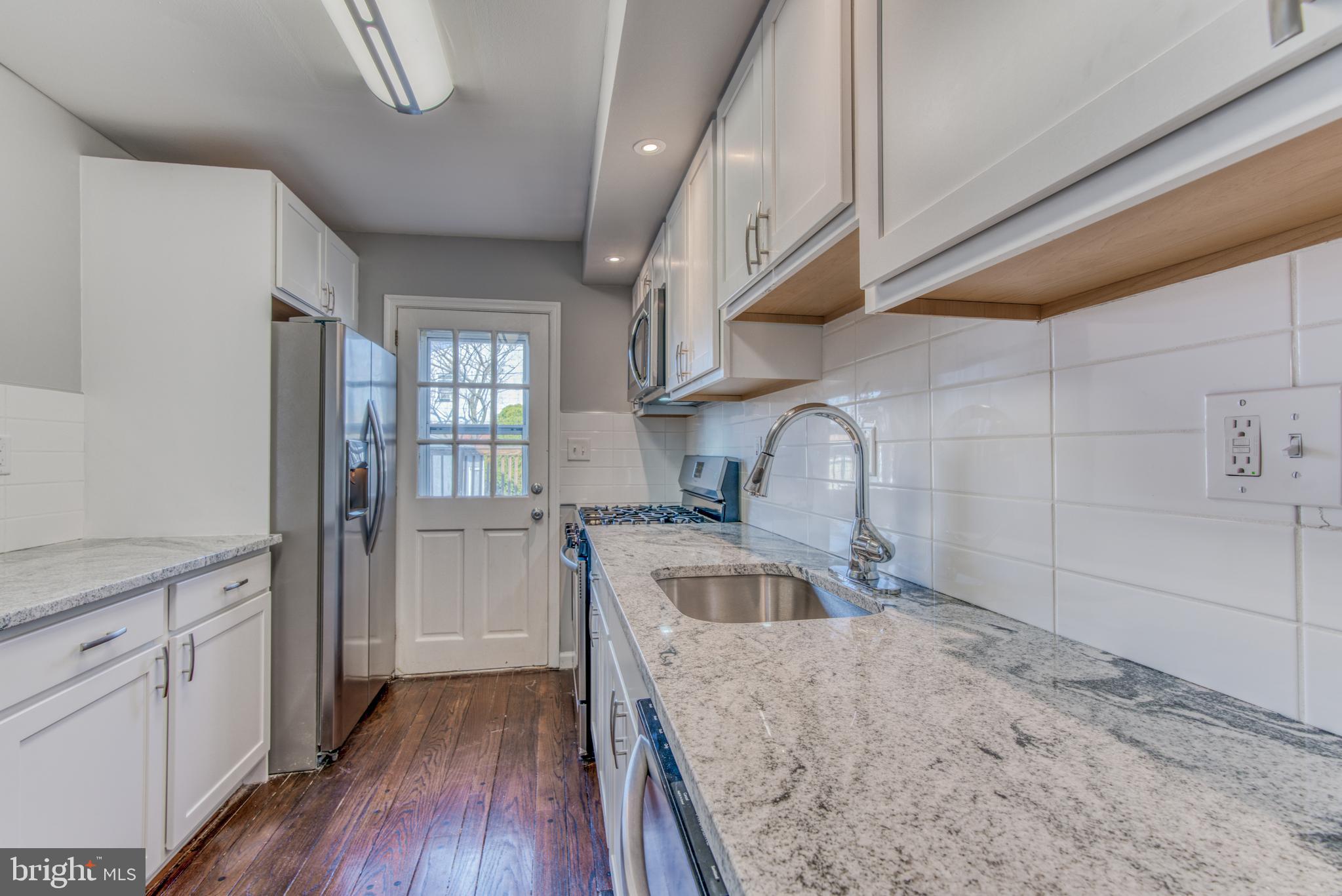 531 Grovethorn Road Baltimore, MD 21220 - Photo 14 of 56 a kitchen with granite countertop a sink wooden floor and stainless steel appliances