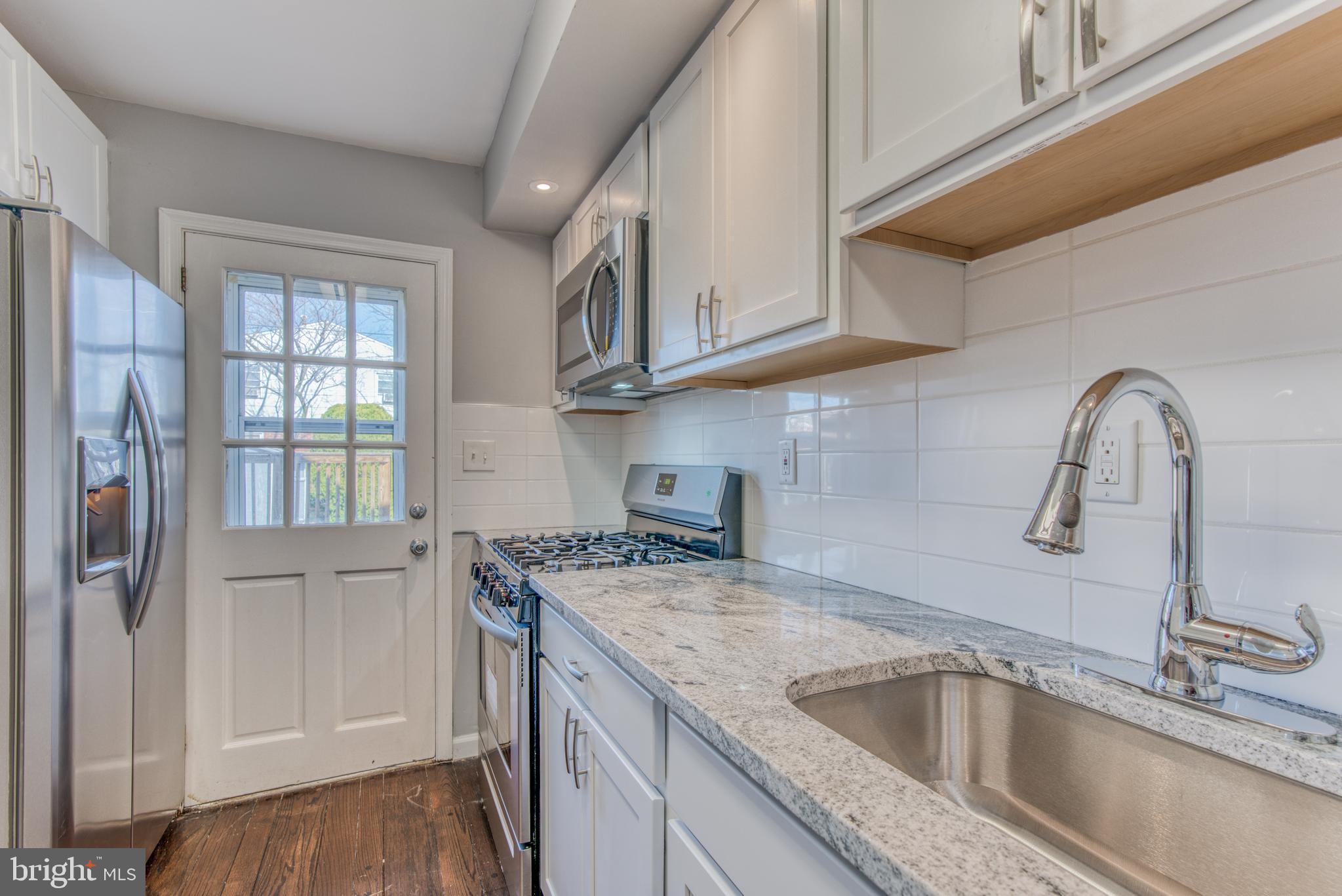 531 Grovethorn Road Baltimore, MD 21220 - Photo 16 of 56 a kitchen with stainless steel appliances granite countertop a sink and a refrigerator