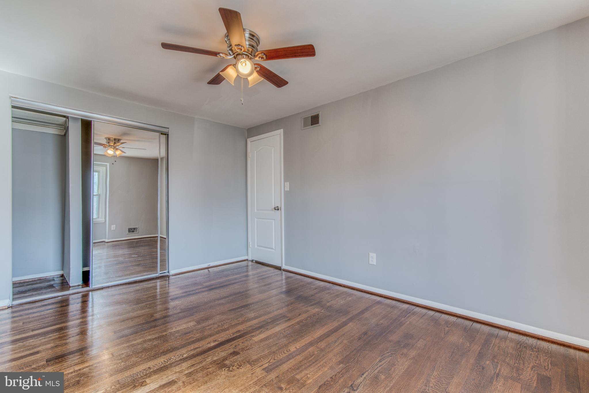 531 Grovethorn Road Baltimore, MD 21220 - Photo 42 of 56 an empty room with wooden floor and chandelier fan