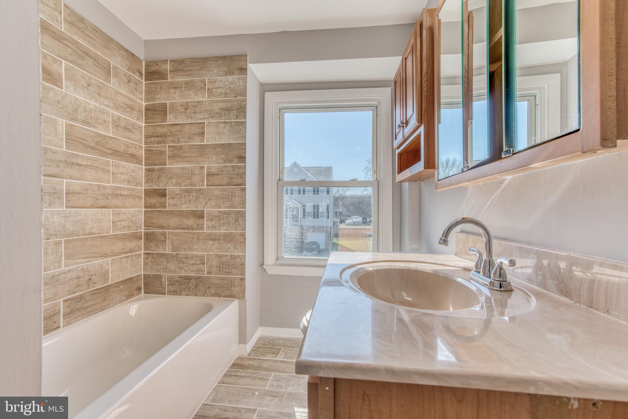 531 Grovethorn Road Baltimore, MD 21220 - Photo 44 of 56 a bathroom with a granite countertop sink a bathtub window and shower