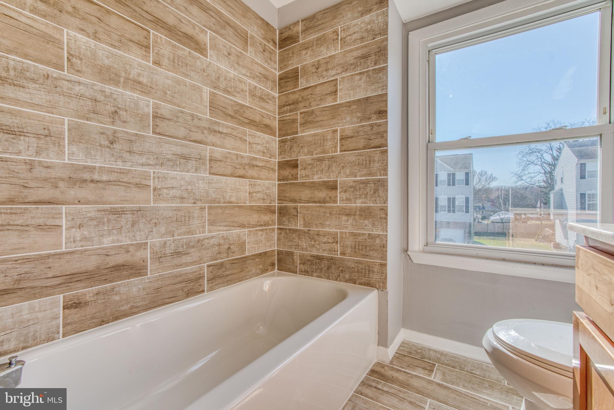 531 Grovethorn Road Baltimore, MD 21220 - Photo 45 of 56 a bathroom with a bathtub and window