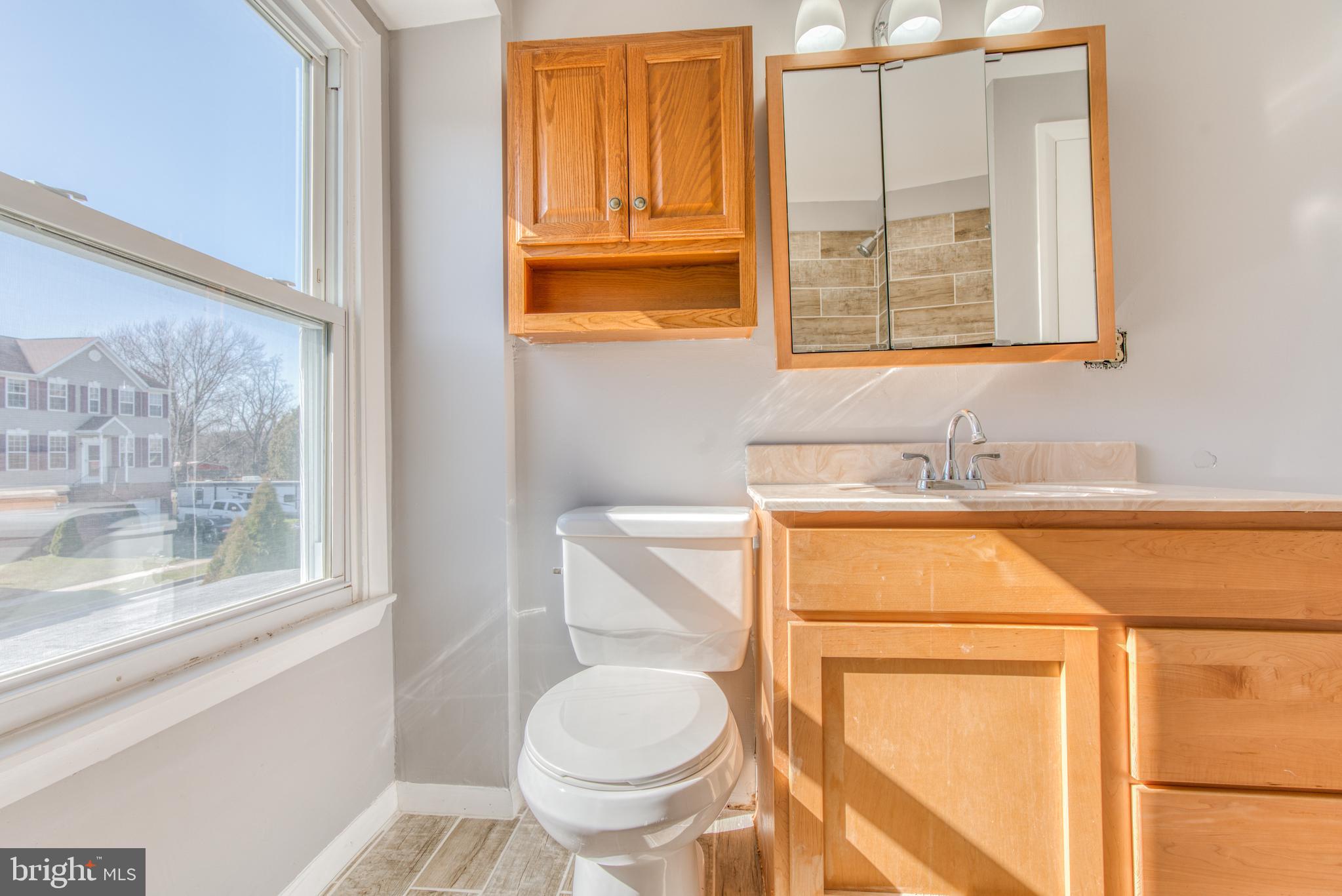 531 Grovethorn Road Baltimore, MD 21220 - Photo 46 of 56 a bathroom with a granite countertop toilet sink and mirror