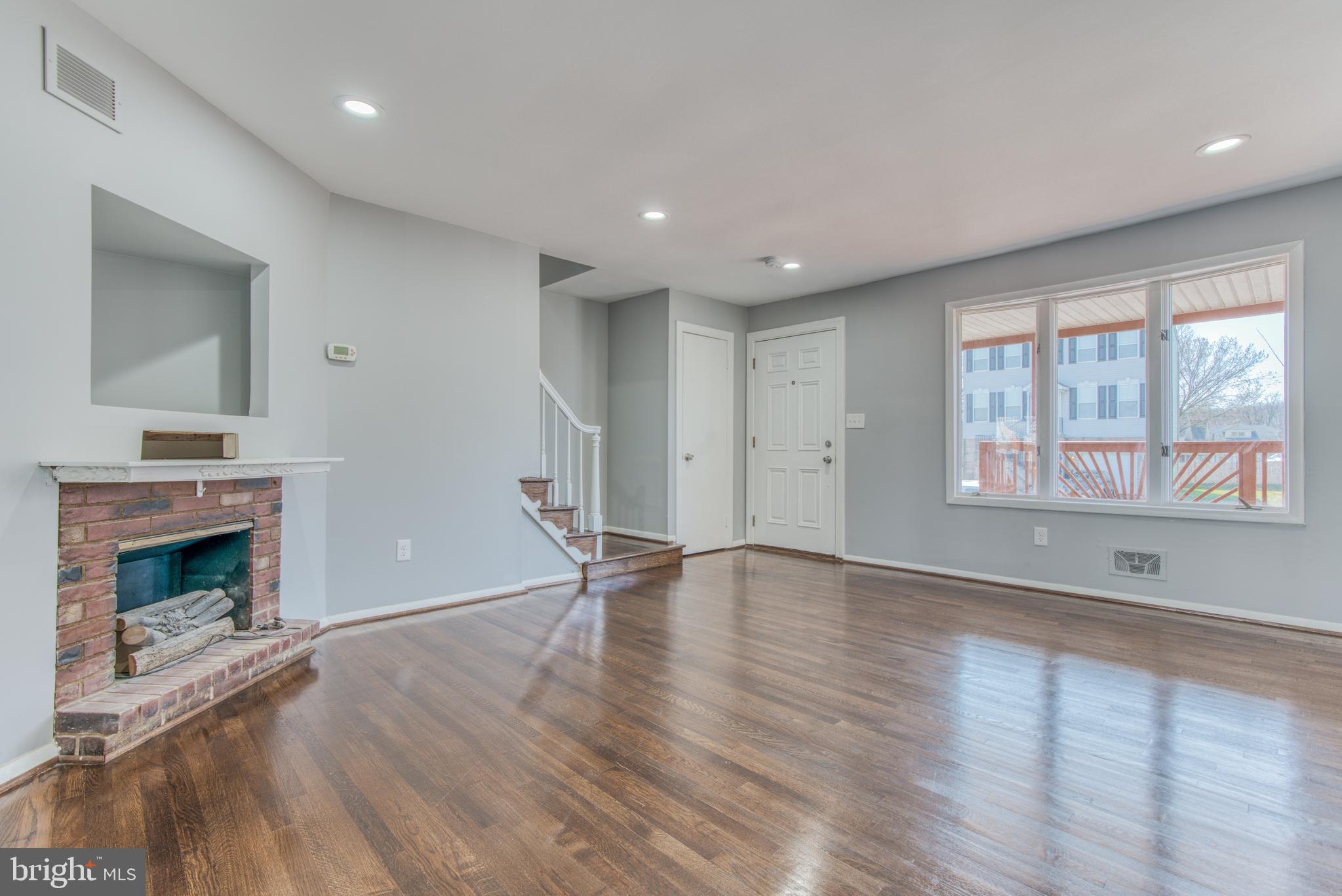 531 Grovethorn Road Baltimore, MD 21220 - Photo 6 of 56 an empty room with wooden floor fireplace and windows