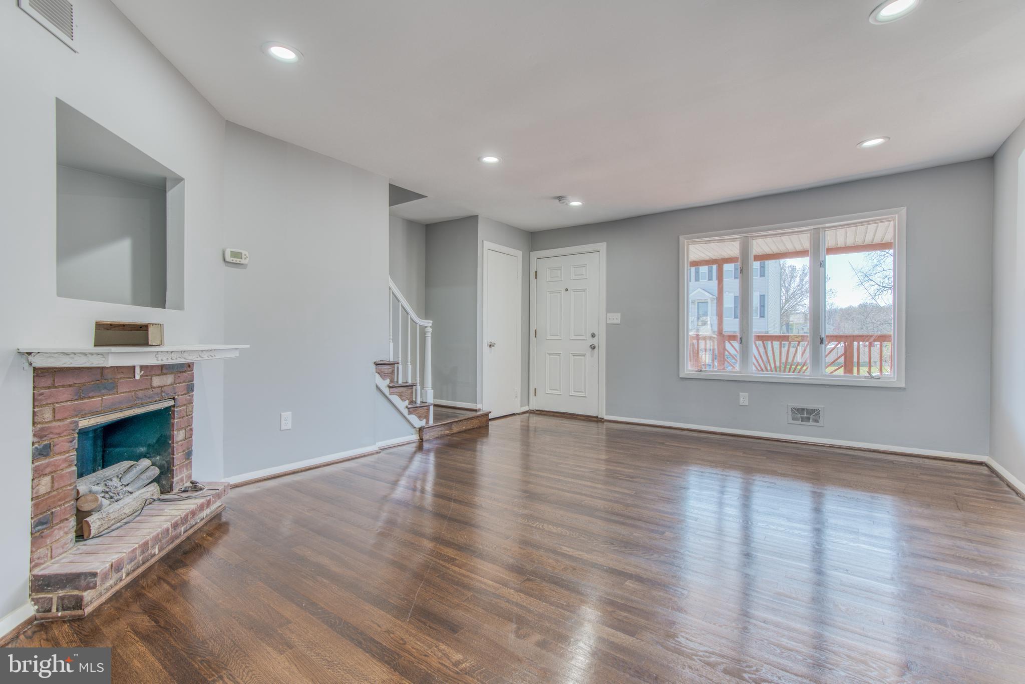 531 Grovethorn Road Baltimore, MD 21220 - Photo 7 of 56 an empty room with wooden floor fireplace and windows