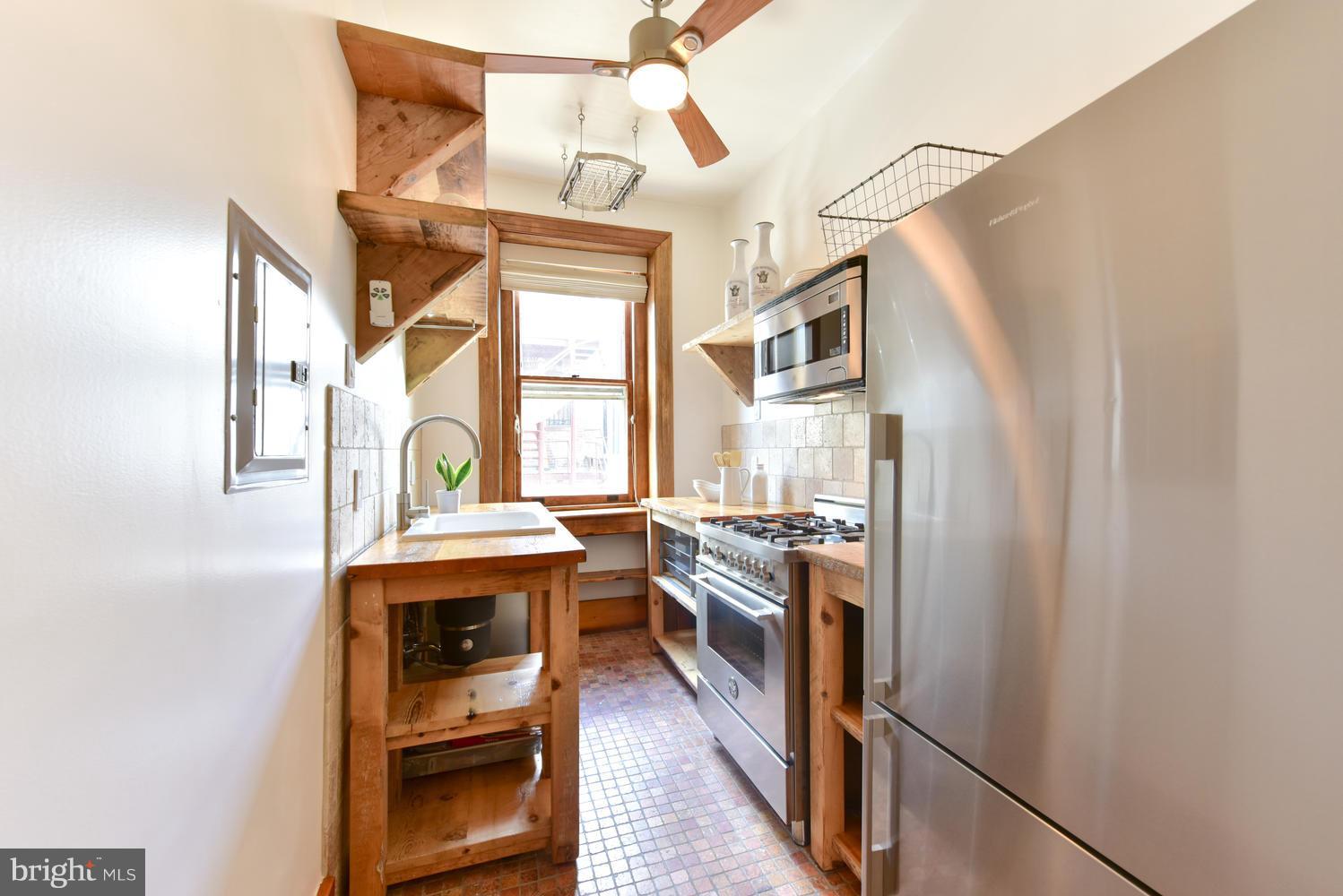 1725 17th Street Northwest, Unit 207 Washington, DC 20009 - Photo 2 of 28 a kitchen with stainless steel appliances granite countertop a stove a sink and a refrigerator