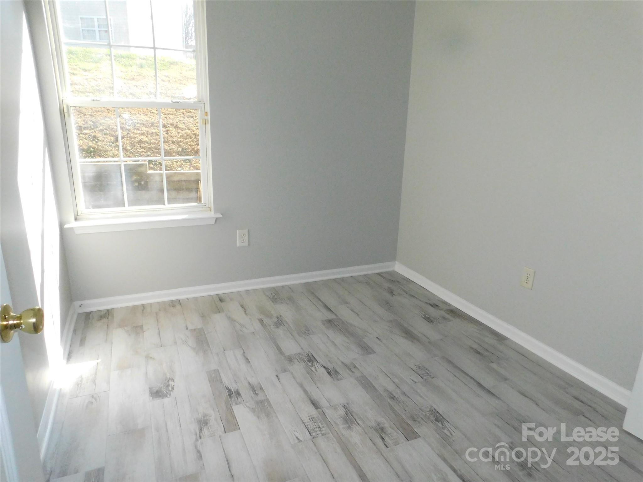 1119 Hannah Rae Court Charlotte, NC 28214 - Photo 11 of 19 an empty room with wooden floor and windows