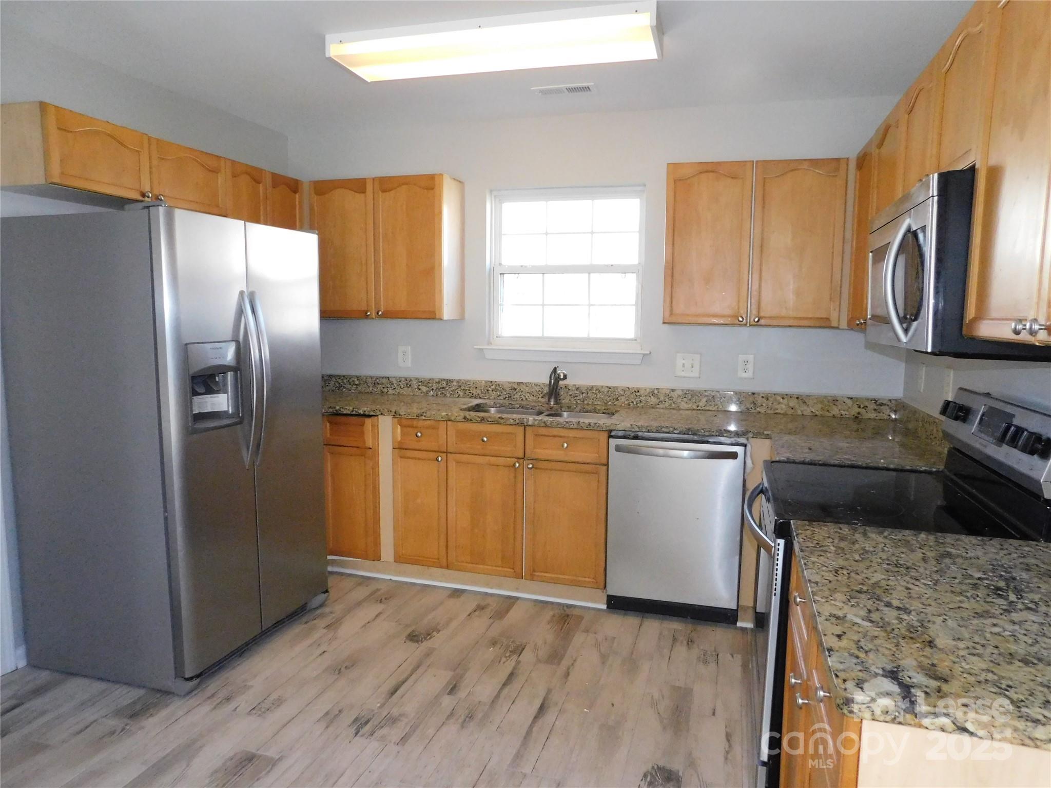 1119 Hannah Rae Court Charlotte, NC 28214 - Photo 2 of 19 a kitchen with granite countertop a refrigerator stove top oven and sink