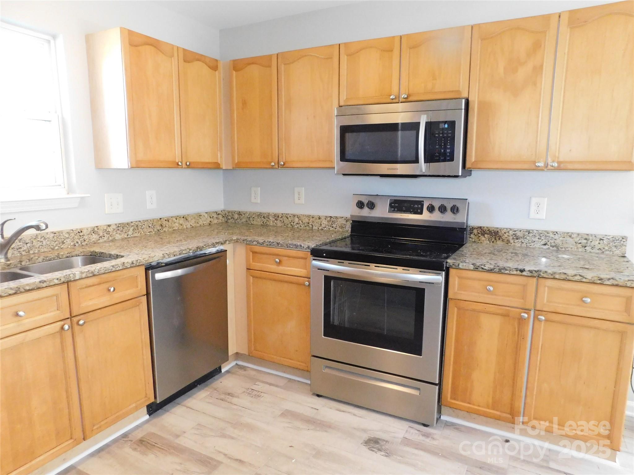 1119 Hannah Rae Court Charlotte, NC 28214 - Photo 3 of 19 a kitchen with granite countertop a stove top oven microwave and cabinets
