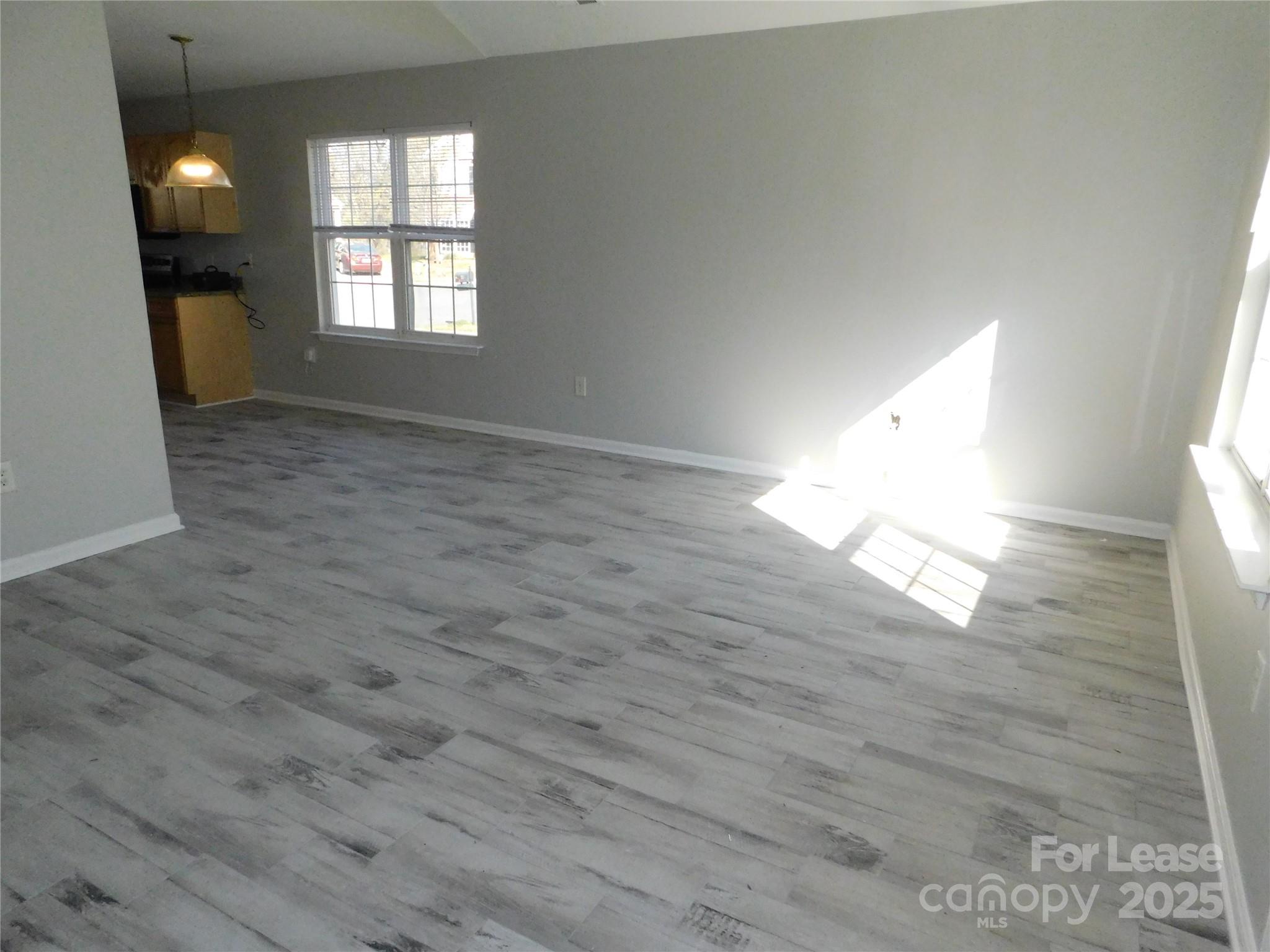 1119 Hannah Rae Court Charlotte, NC 28214 - Photo 7 of 19 an empty room with wooden floor and windows