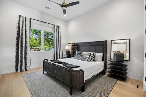 a bedroom with a bed lamp and a large window