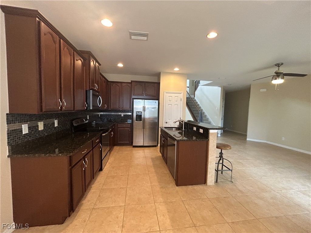 Undisclosed Address Cape Coral, FL 33991 - Photo 5 of 40 a kitchen with a sink cabinets and stainless steel appliances