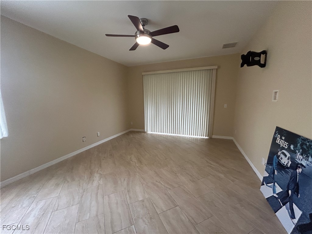 Undisclosed Address Cape Coral, FL 33991 - Photo 8 of 40 an empty room with wooden floor and ceiling fan