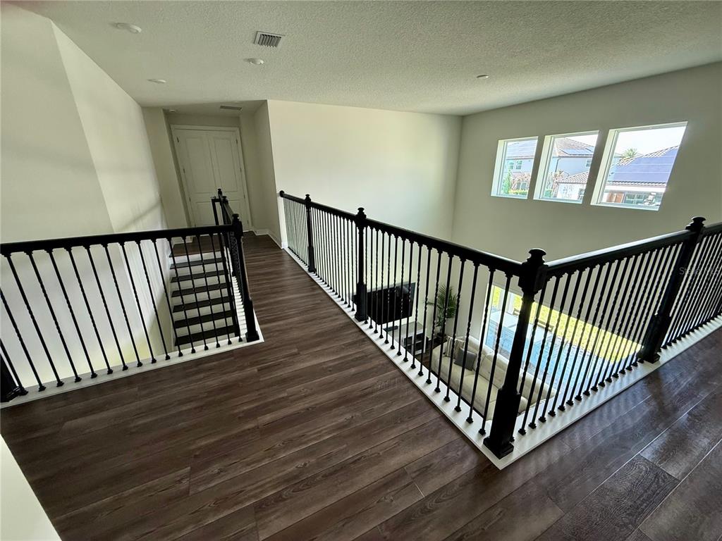 8441 Pk Clf Way Orlando, FL 32836 - Photo 22 of 59 a view of a hallway with wooden floor and stairs