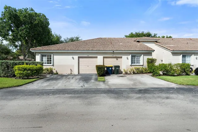 a front view of a house with a yard and a garage