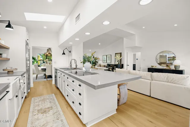 a large kitchen with a sink and chandelier