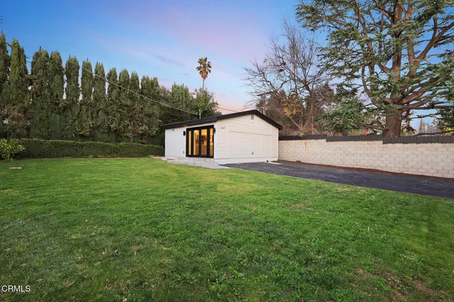 an aerial view of a house with a yard and a large tree