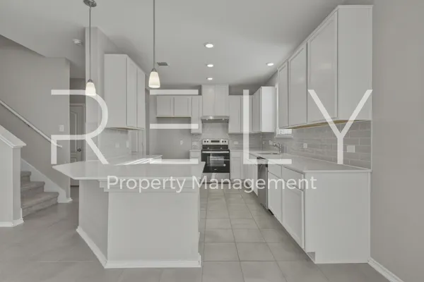 a kitchen with stainless steel appliances granite countertop a refrigerator a sink and a stove