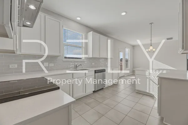 a kitchen with white cabinets appliances and a window