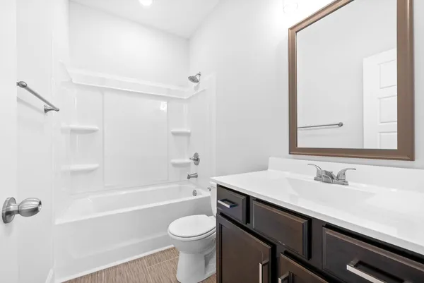 a bathroom with a sink a toilet a mirror and shower