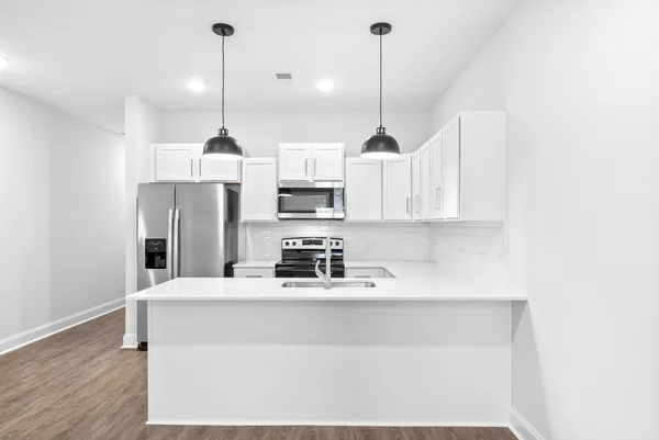 a kitchen with stainless steel appliances granite countertop a sink a refrigerator a center island a stove and cabinets