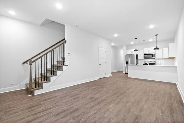 a view of a kitchen with wooden floor and electronic appliances