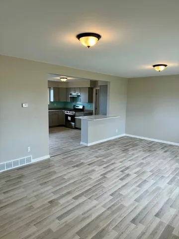 a view of a kitchen and dining room with wooden floor