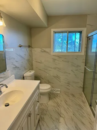 a bathroom with a sink a toilet and shower