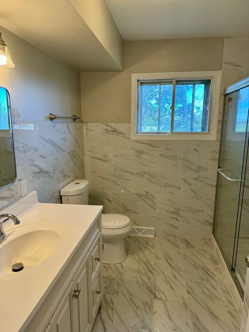 18708 Beck Road Marengo, IL 60152 - Photo 9 of 16 a bathroom with a sink a toilet and shower