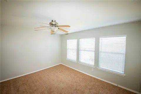 an empty room with a window and a fan