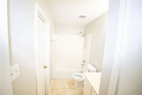 a bathroom with a granite countertop sink a toilet and shower
