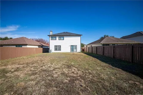 a view of a house with a yard and large tree