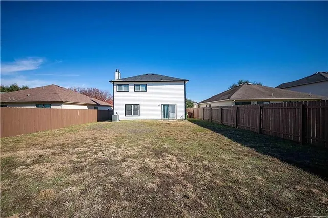 a view of a house with a yard and large tree