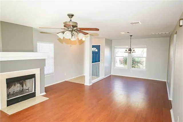a view of an empty room with a fireplace and a window