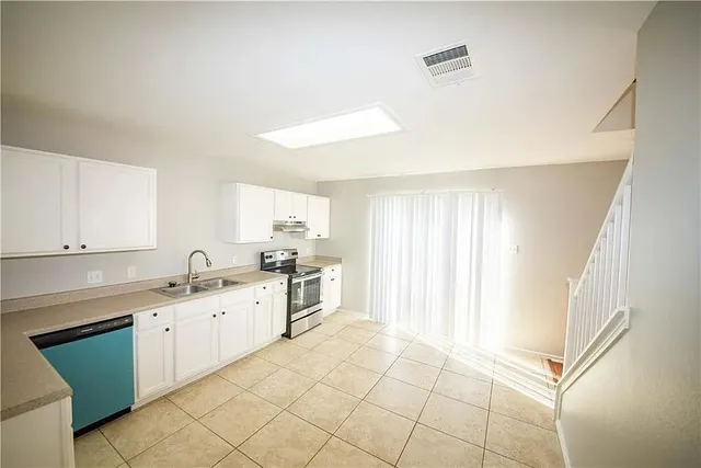 a kitchen with granite countertop white cabinets and white appliances