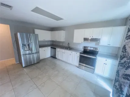 a kitchen with stainless steel appliances granite countertop a stove top oven a sink and dishwasher