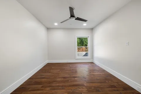 a view of empty room with wooden floor
