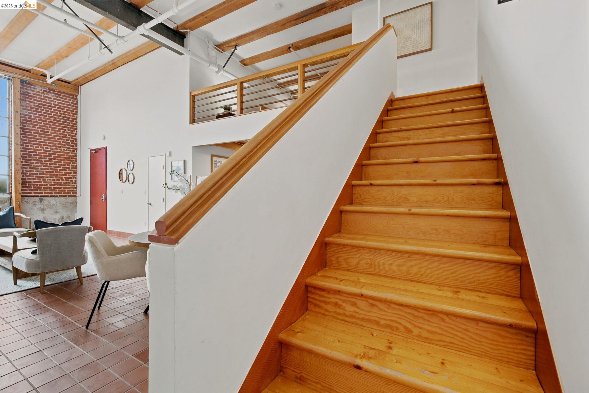 1920 Union Street, Unit 9 Oakland, CA 94607 - Photo 18 of 35 Natural wood staircase with matching handrail leading to an upper landing