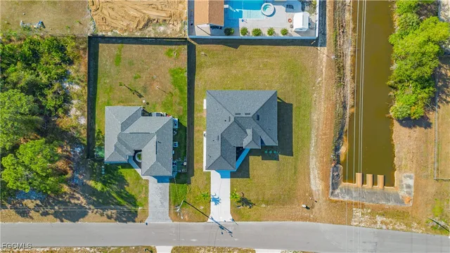 an aerial view of residential houses with yard