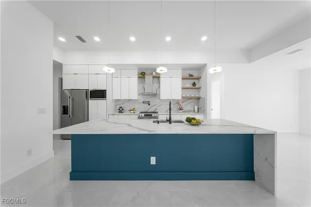 a kitchen with kitchen island sink stove and refrigerator