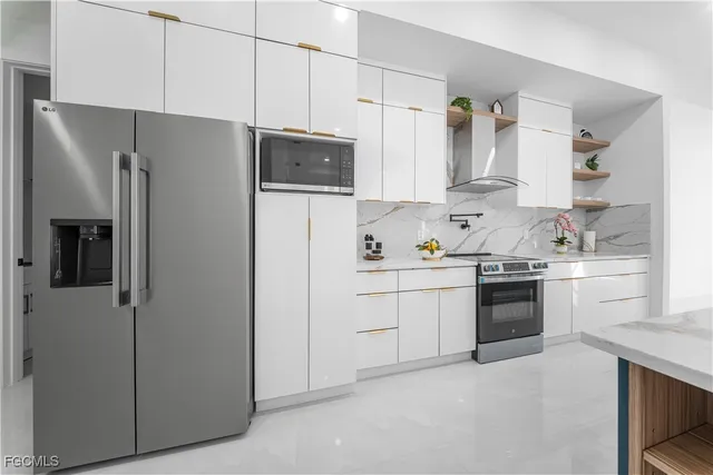 a kitchen with stainless steel appliances white cabinets and a refrigerator