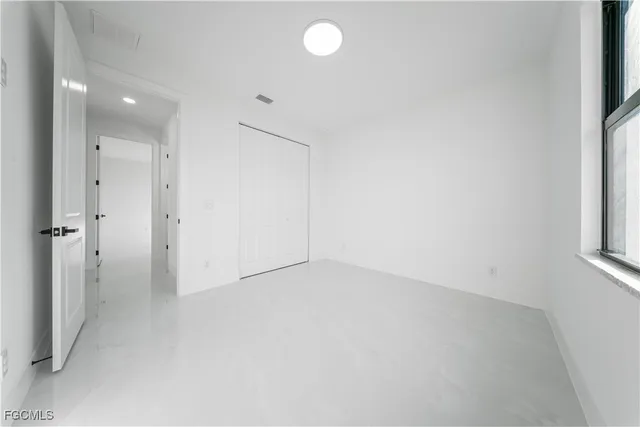 an empty room with windows and closet