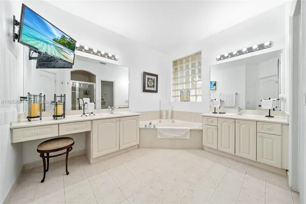 a large bathroom with a double vanity sink a mirror and a bathtub