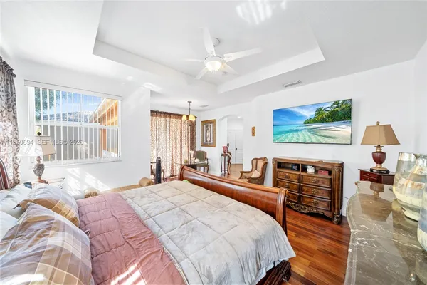a bedroom with a bed wooden floor and window