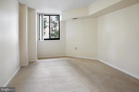 an empty room with windows and closet